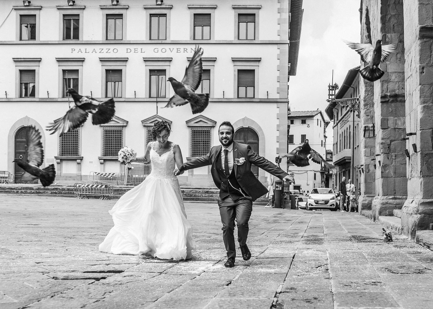 fotografo di matrimonio a pistoia gli sposi in piazza duomo rincorrono piccioni